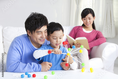 Young Chinese boy with parents and toys in the living room