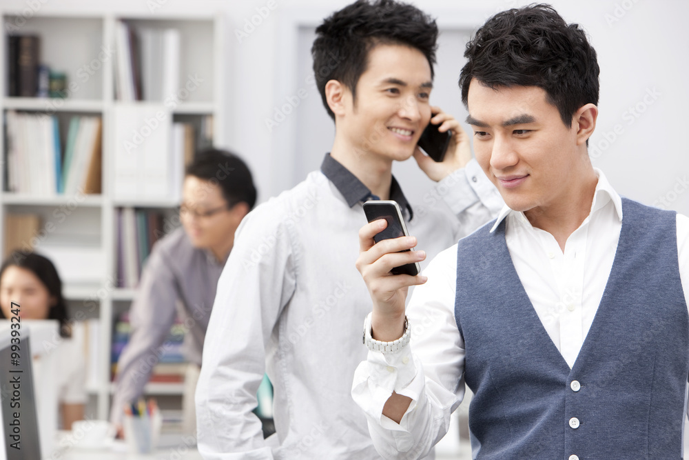 Happy business colleagues with smart phones in the office Happy business colleagues with smart phones in the office