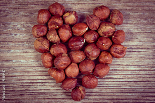 Vintage photo, Heart of brown hazelnut on wooden table