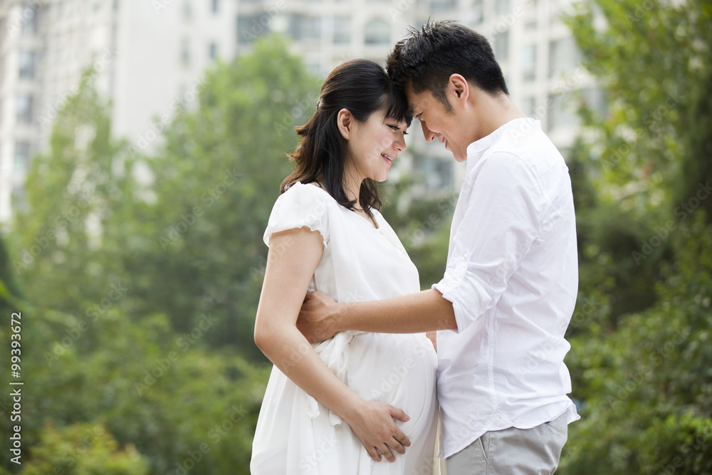 Pregnant woman and her husband embracing Pregnant woman and her husband embracing