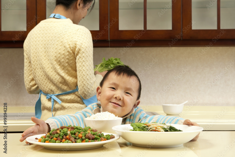 Young boy holding plates of food at the dinner table Young boy holding plates of food at the dinner table