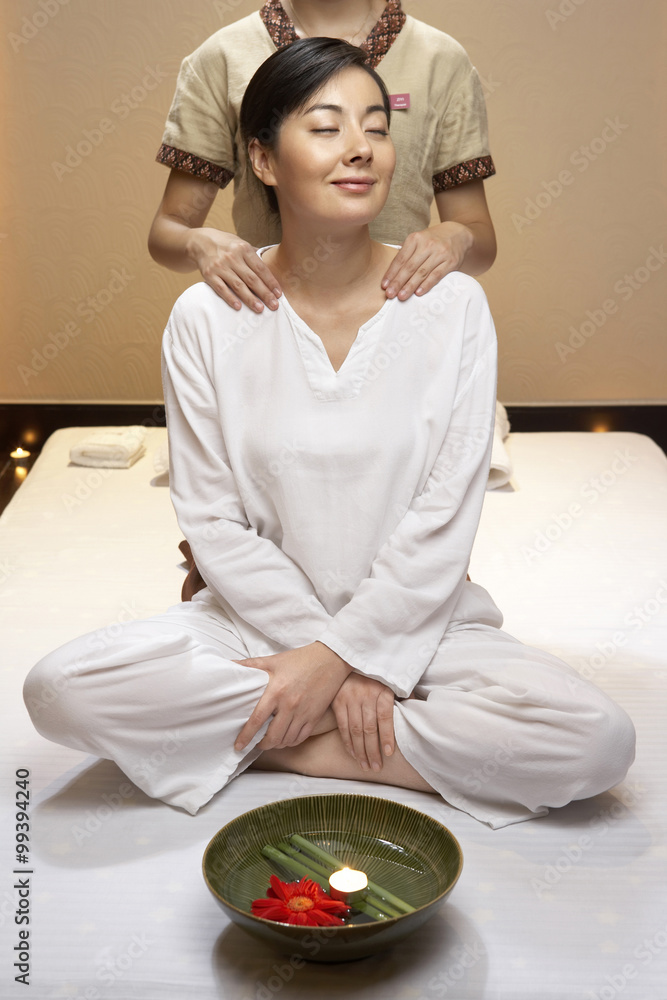 Spa attendant giving a shoulder massage to woman Spa attendant giving a shoulder massage to woman