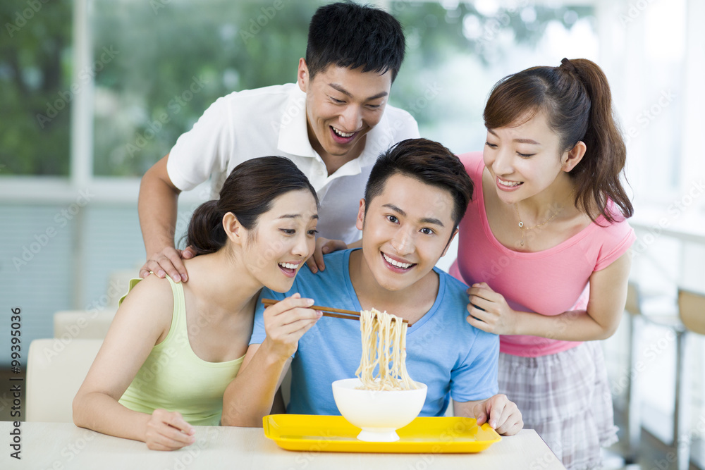 Young adults having noodles in restaurant Young adults having noodles in restaurant