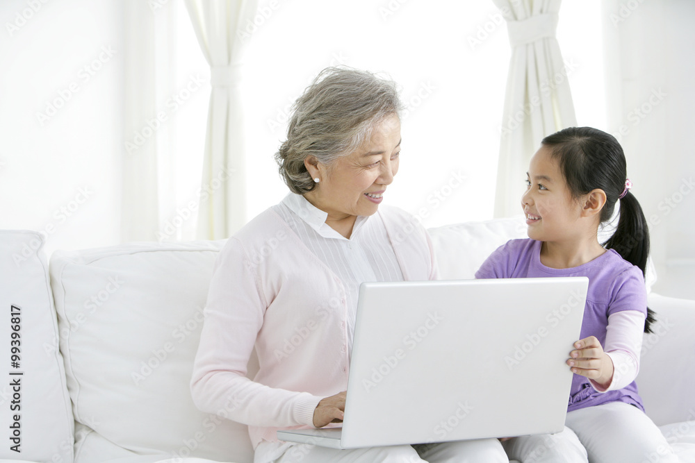 Chinese grandmother with grandaughter using a laptop Chinese grandmother with grandaughter using a laptop