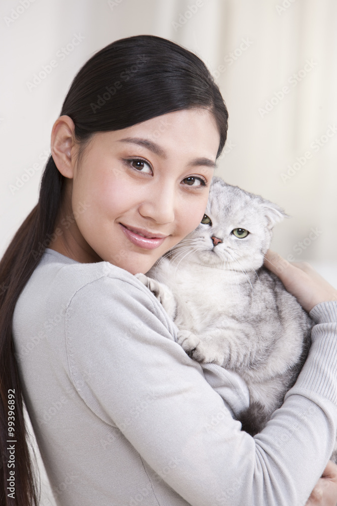 Young woman playing with a Scottish Fold cat Young woman playing with a Scottish Fold cat