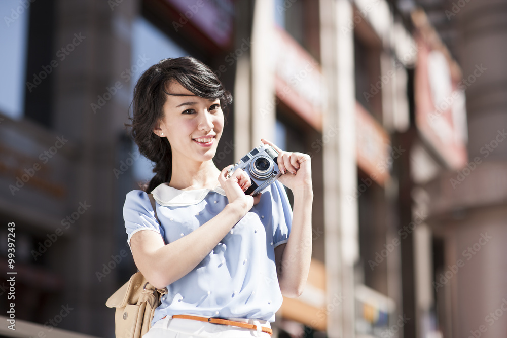 Stylish young woman with a camera