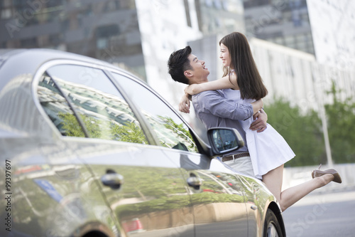 Young couple embracing next to their car © Blue Jean Images