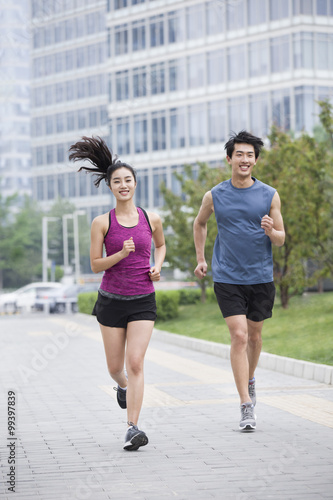 Young couple running outside