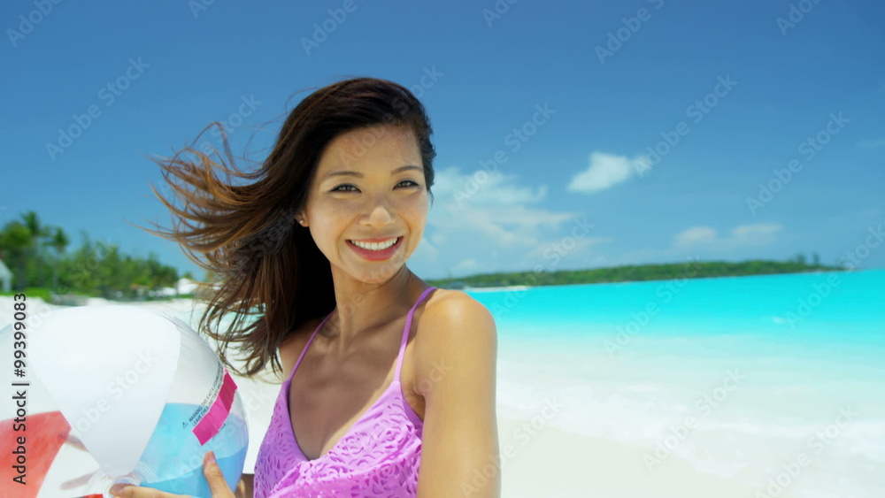 Young Asian Chinese female wearing bikini holding beach ball Young Asian Chinese female wearing bikini holding beach ball