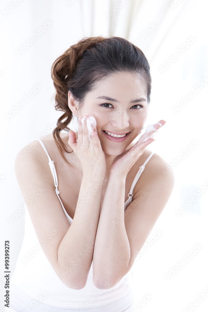 Young woman using facial cleanser to wash face Young woman using facial cleanser to wash face