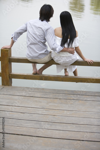 Young couple sitting by lake