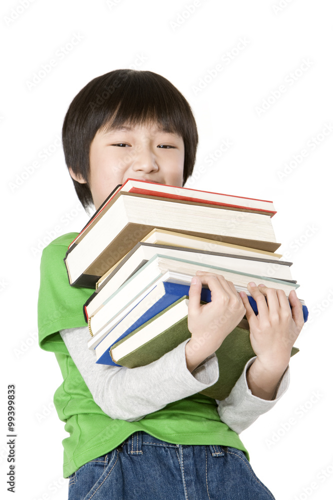 Young boy carrying a large stack of books Young boy carrying a large stack of books