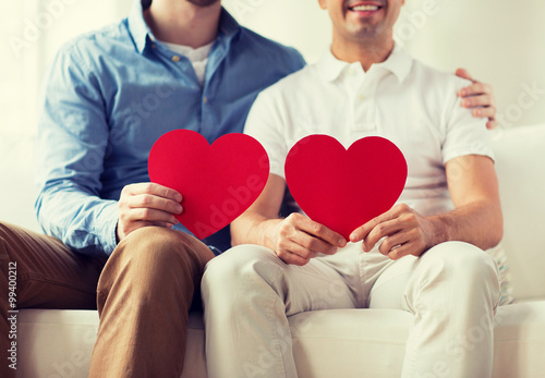 close up of happy gay male couple with red hearts