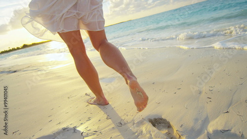 Caucasian female walking barefoot on the beach 