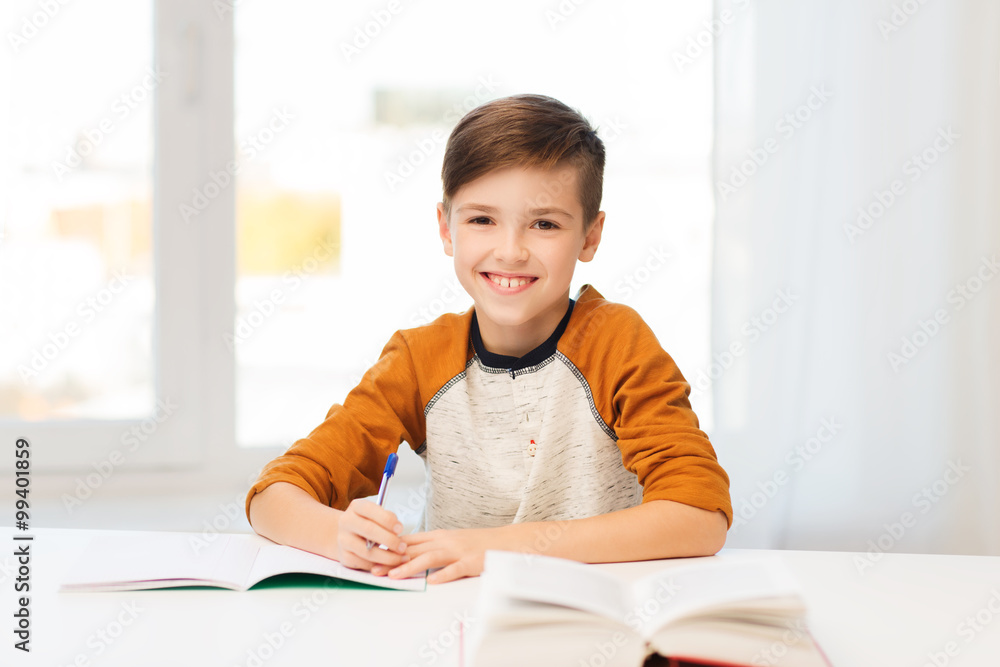 smiling student boy writing to notebook at home smiling student boy writing to notebook at home