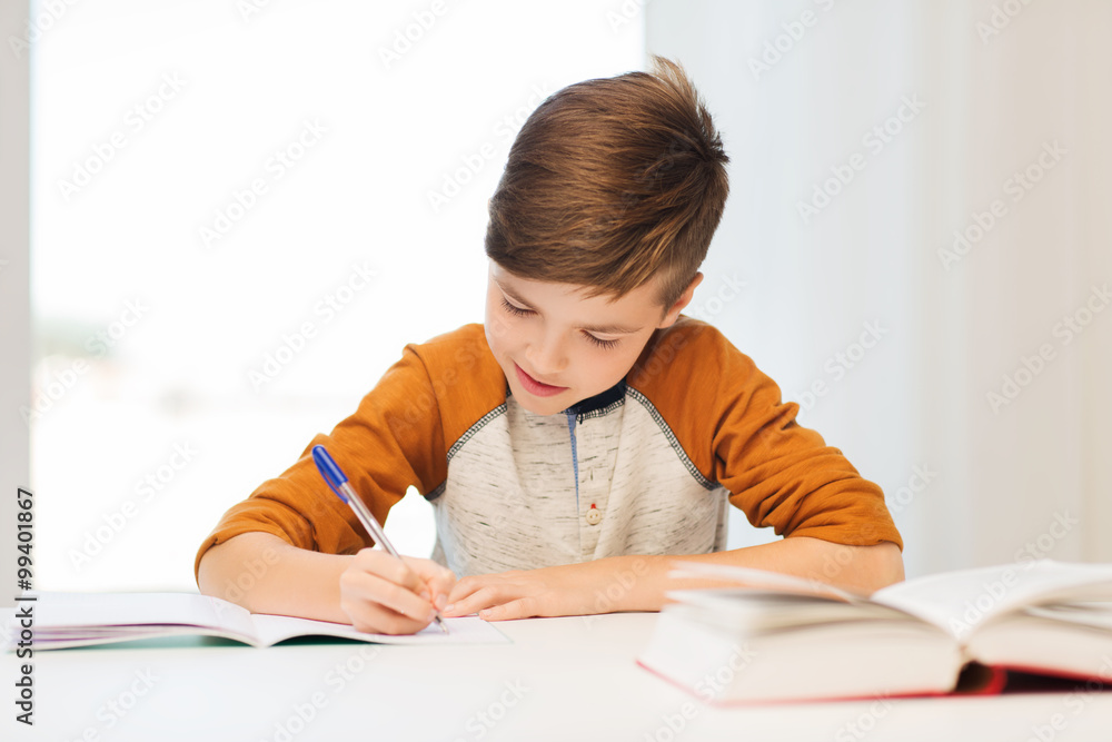 smiling student boy writing to notebook at home smiling student boy writing to notebook at home