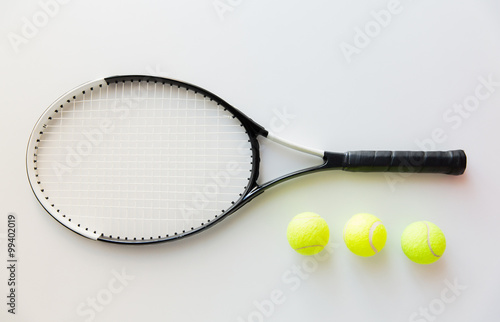 close up of tennis racket with balls