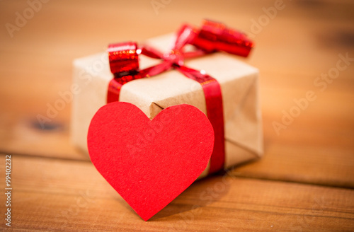 close up of gift box and heart shaped note on wood photo