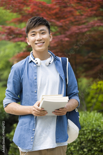 Happy male college student with books photo