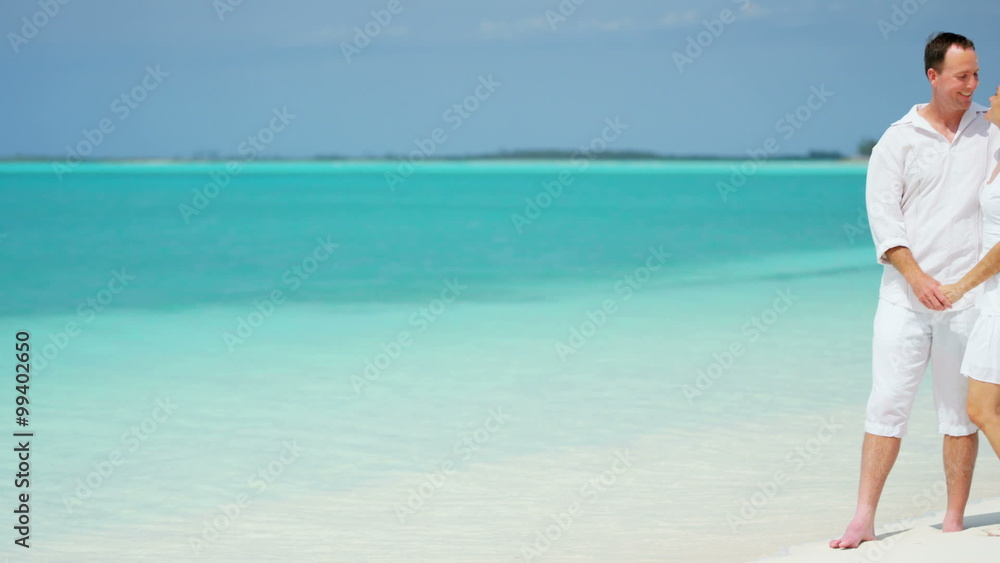 happy Caucasian male female couple white clothing sand ocean island vacation happy Caucasian male female couple white clothing sand ocean island vacation