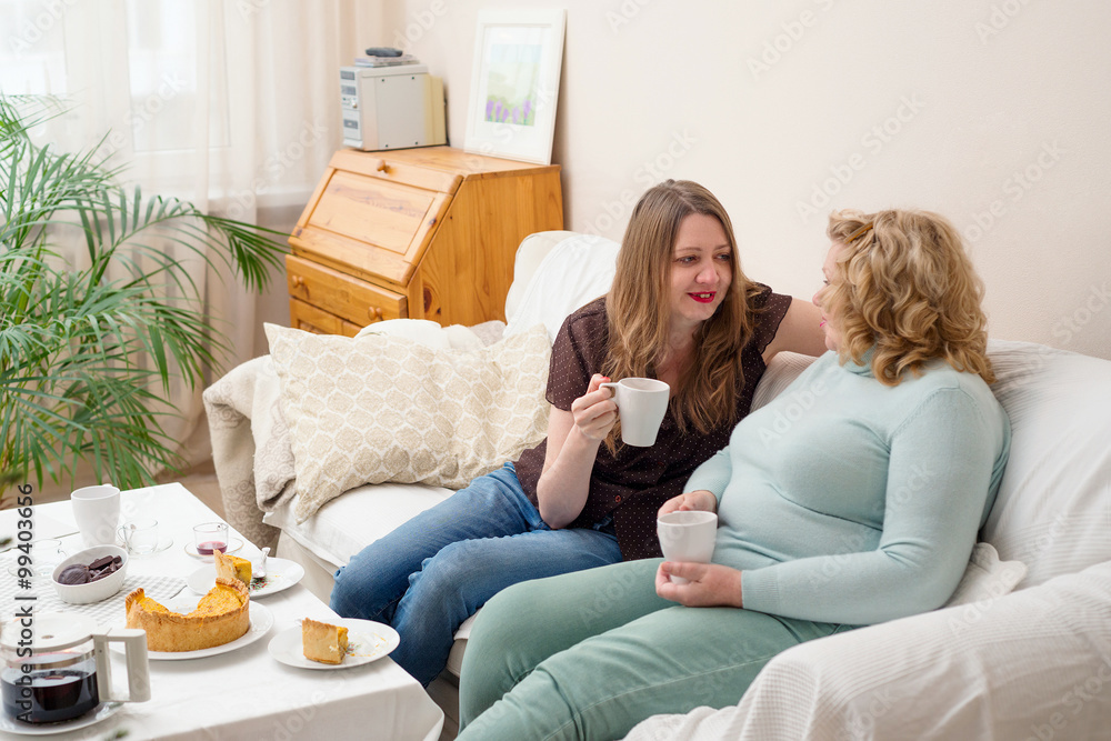 Two women drinking tea and talking. Mother and daughter.