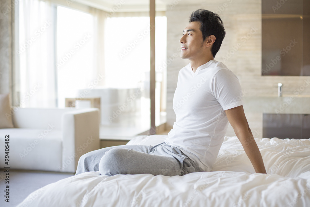 Young man sitting on bed Young man sitting on bed