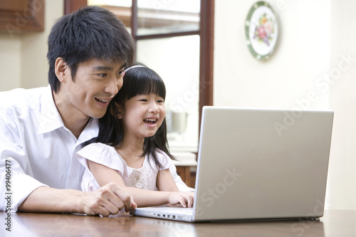 Father and daughter using laptop © Blue Jean Images