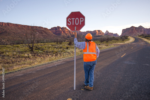 A construction worker stopping traffic, holding a stop sign.