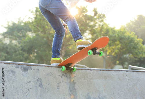 young woman skateboarder skateboarding at sunrise skatepark