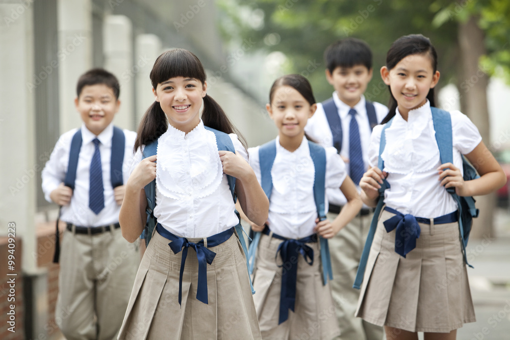Lovely schoolchildren in uniform on the way to school Lovely schoolchildren in uniform on the way to school