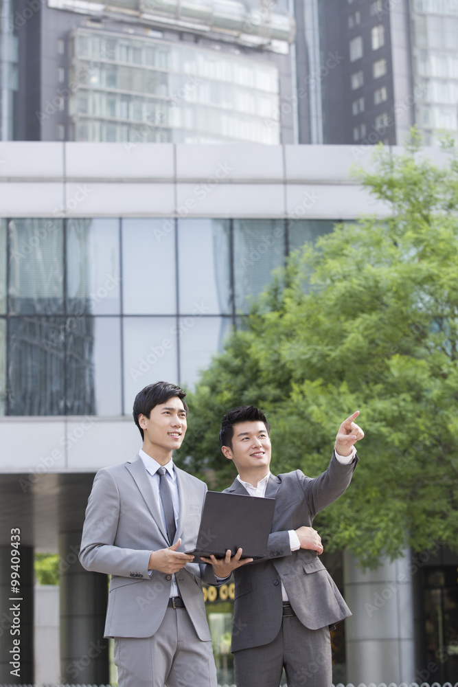 Young business person working with laptop outdoors Young business person working with laptop outdoors