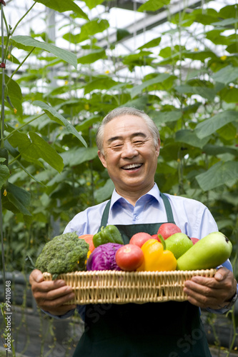 Farmer holding vegetables in modern farm © Blue Jean Images