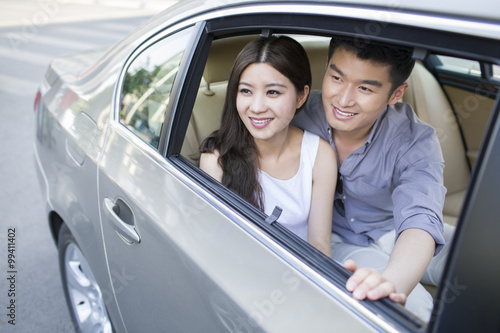 Happy young couple in a car