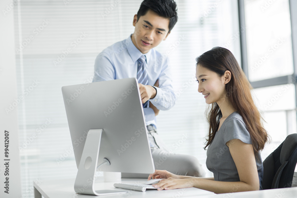 Young businesswoman and businessman talking in office Young businesswoman and businessman talking in office