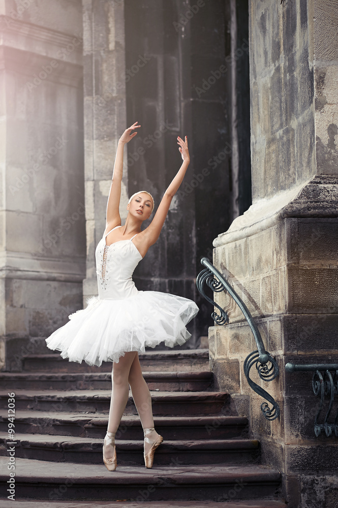 Obraz premium Looks weightless. Beautiful young elegant ballerina dancing on the stairway soft focus