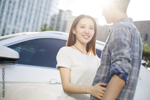 Happy young couple and car