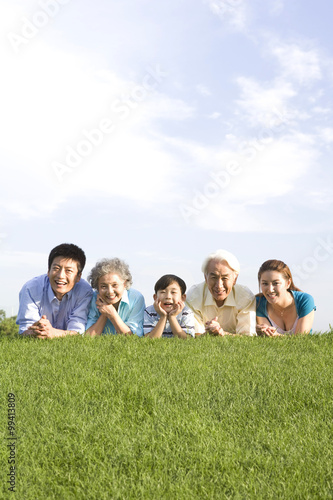 Three generation family lying on the grass
