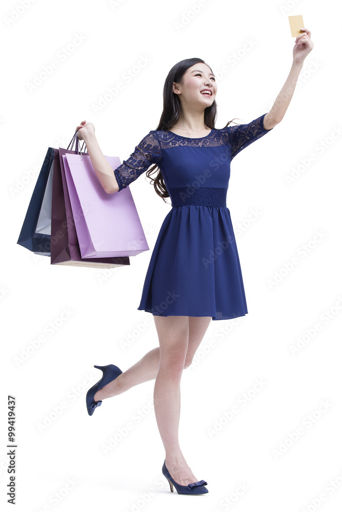 Happy young woman with shopping bags and credit card