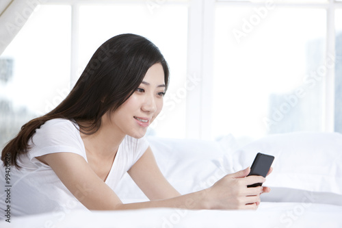 Young woman holding cellphone at home