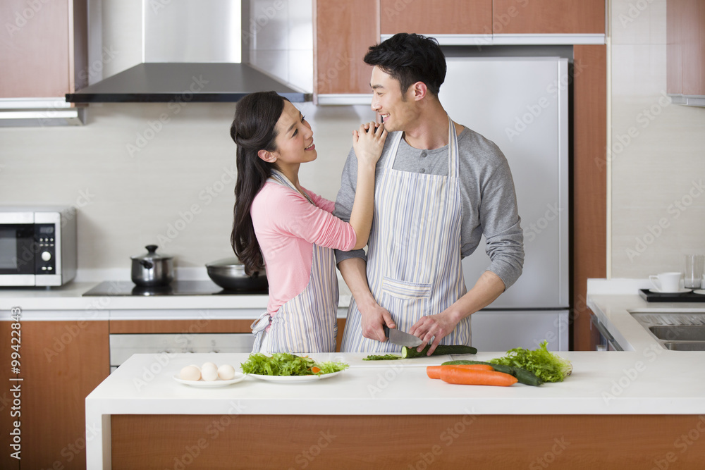 Happy young couple preparing meal