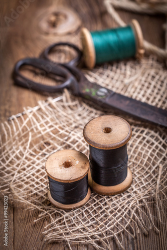 Old sewing kit on the wooden table.