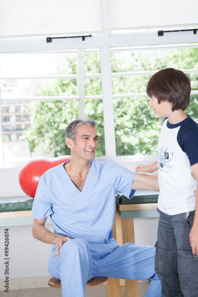 Obraz premium Male therapist with boy in rehab
