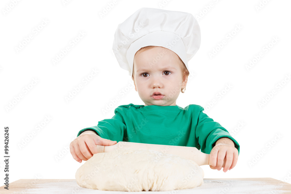 Serious little boy kneading dough for the cookies, isolated on white Serious little boy kneading dough for the cookies, isolated on white