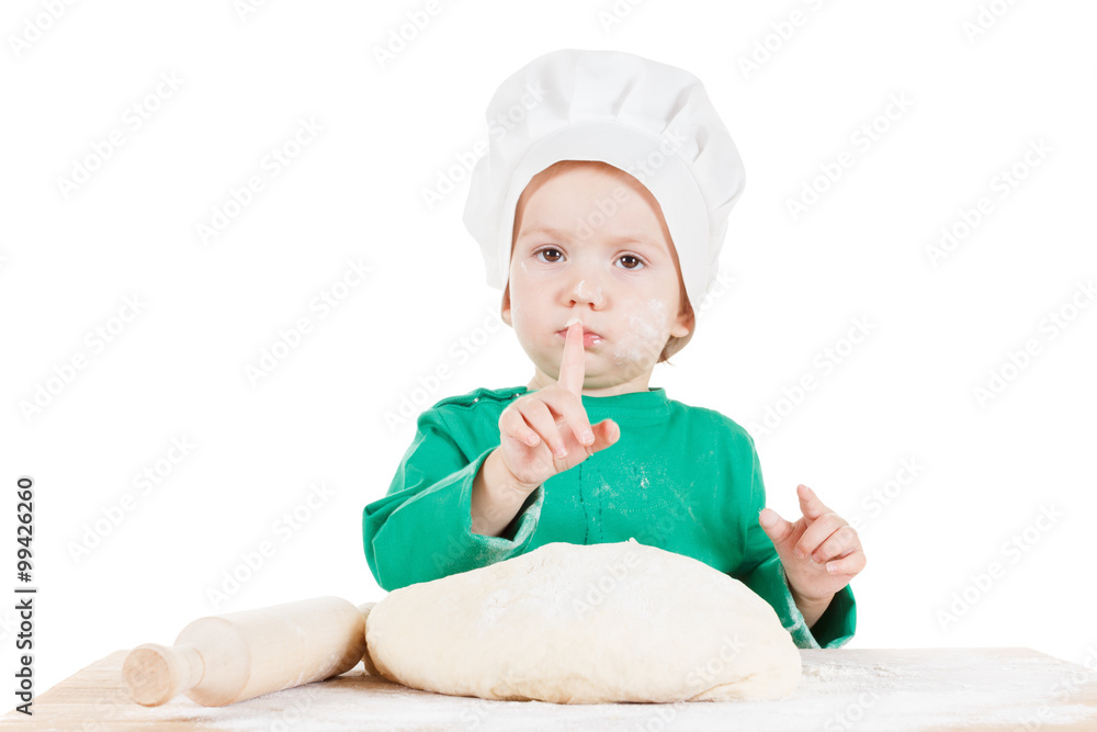Serious little boy kneading dough for the cookies, isolated on white Serious little boy kneading dough for the cookies, isolated on white