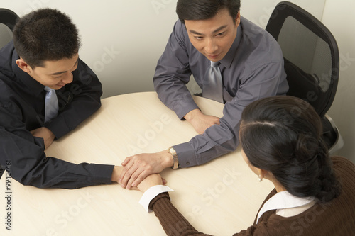 Businesspeople Shaking Hands Around A Table
