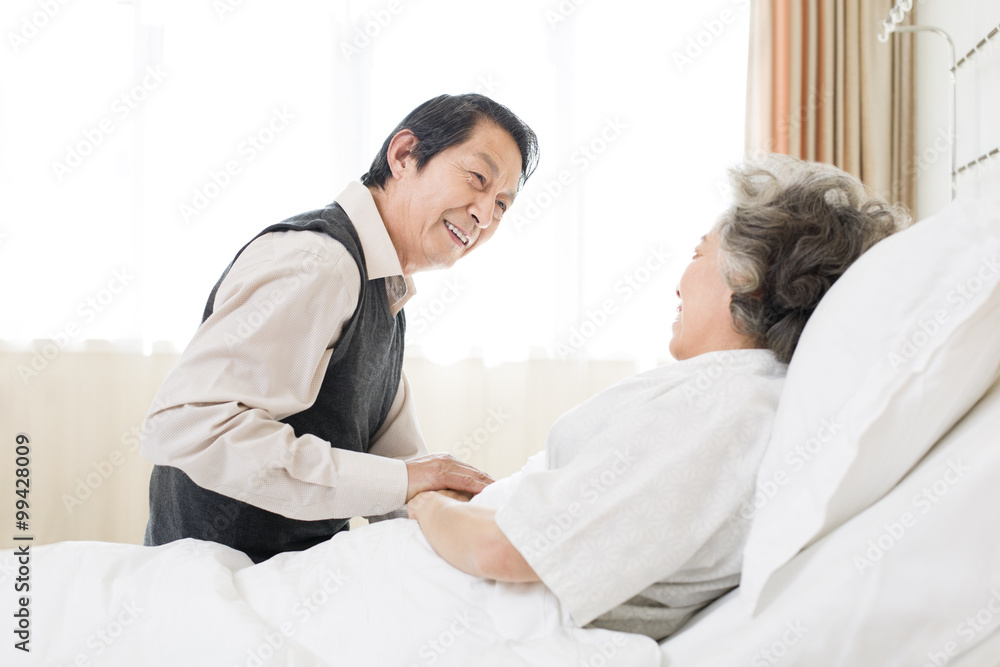 Senior man taking care of wife in hospital Senior man taking care of wife in hospital