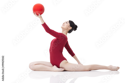 Female rhythmic gymnast performing with ball photo