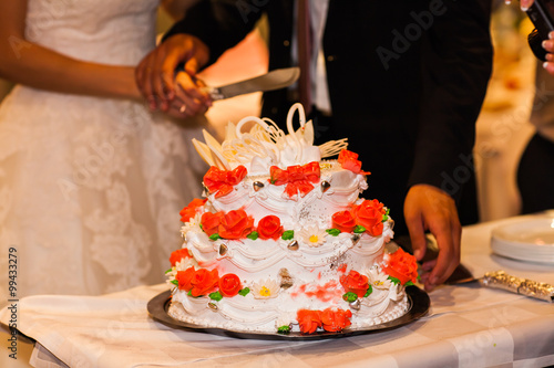 The bride and groom cut the wedding cake