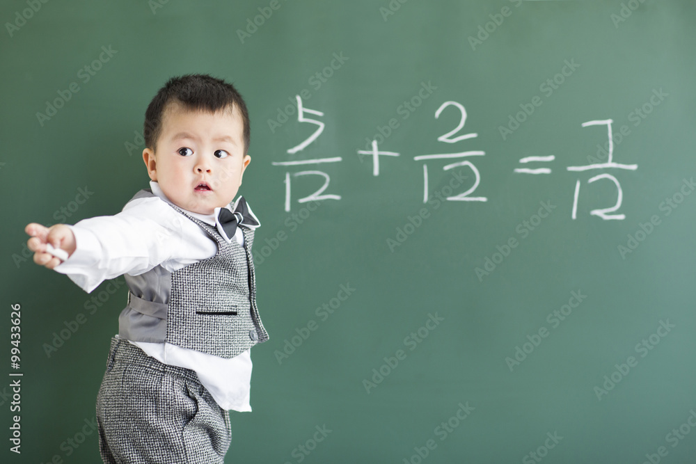 Cute baby doing mathematics on blackboard Cute baby doing mathematics on blackboard