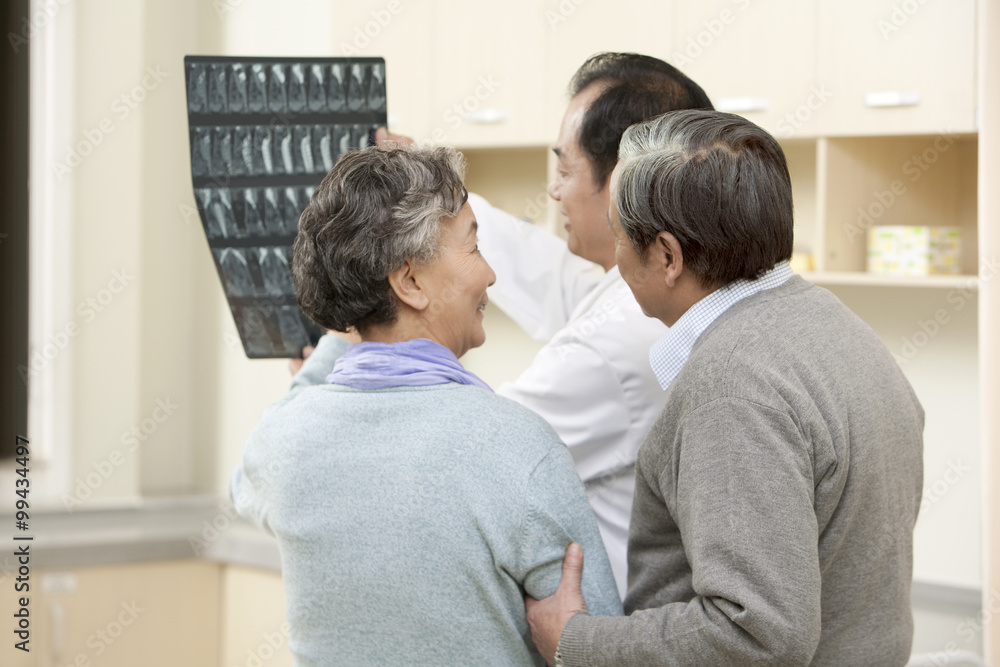 Doctor Shows an X-Ray Test Results to Senior Couple Doctor Shows an X-Ray Test Results to Senior Couple